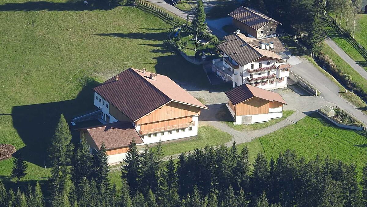 Huterhof w lecie: tutaj widac nowo wybudowany budynek gospodarczy i dom mieszkalny, za którym znajduje sie plac zabaw.