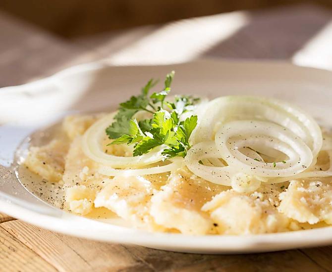 Graukäse angerichtet mit hausgemachtem Weinessig und Zwiebelringe