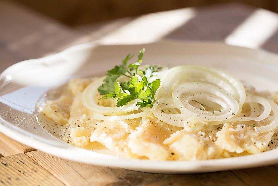 Graukäse angerichtet mit hausgemachtem Weinessig und Zwiebelringe