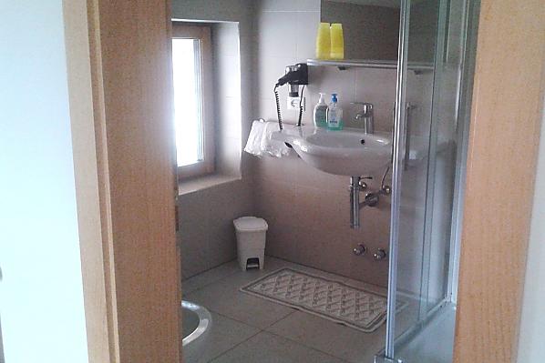 Bad mit Dusche und Duschkabine, Waschbecken, WC und Bidet.