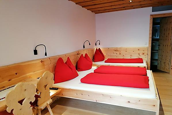 Dreibettschlafzimmer aus Zirbenholz mit Naturholzboden 