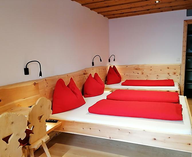 Dreibettschlafzimmer aus Zirbenholz mit Naturholzboden 
