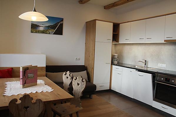 Küche mit Backrohr, Kühlschrank, Kaffeemaschine, Ceranfeld, Spülmaschine und Wasserkocher