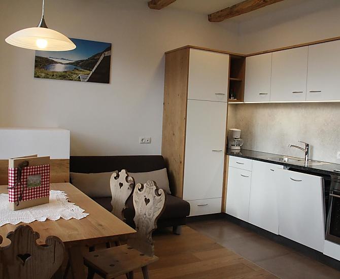 Küche mit Backrohr, Kühlschrank, Kaffeemaschine, Ceranfeld, Spülmaschine und Wasserkocher