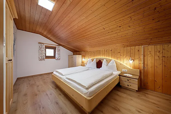 Schlafzimmer mit Holzboden und auf Wunsch zwei Klappbetten.