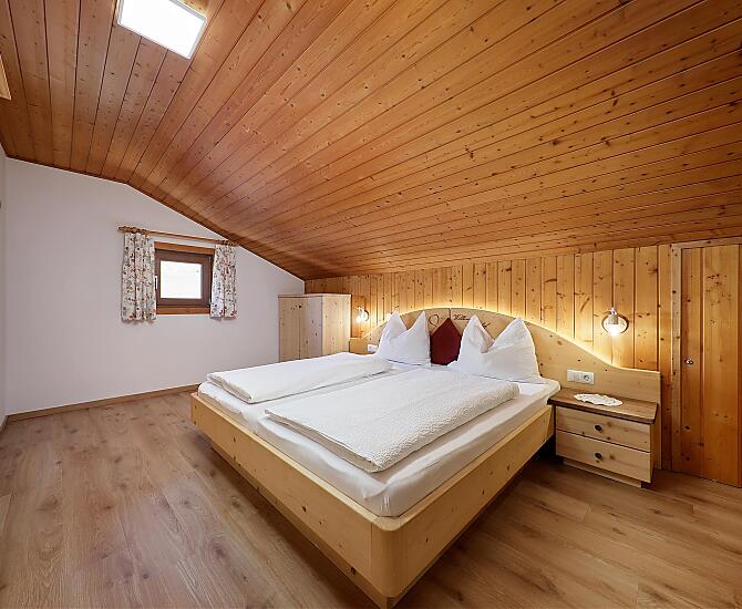 Schlafzimmer mit Holzboden und auf Wunsch zwei Klappbetten.