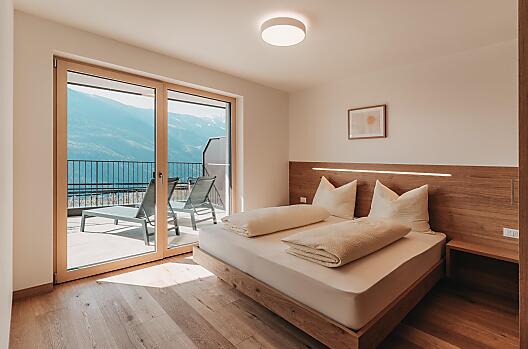 Schlafzimmer aus natürlichen Materialien und Zugang zur Sonnenterrasse