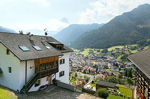 Hof mit Aussicht aufs Dorf und die Dolomiten