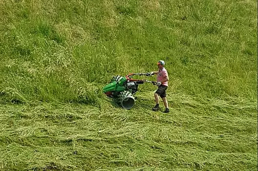 Nasz gospodarz i rolnik Herbert kosi trawe na naszych stromych górskich lakach kosiarka z zebatym walkiem.
